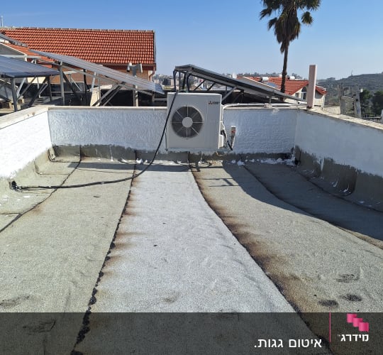 גג עם יריעות איטום ומזגן חיצוני